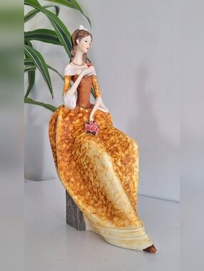 Figurine of a lady holding a bouquet of roses